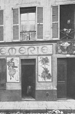 13 rue de la Grande Chaumière: Madame Charlotte Caron at the window above her crémerie (panel by Mucha to the left, by Slewinsky to the right)